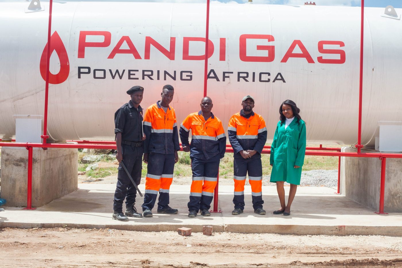 Pandi Energy team in front of a branded Pandi Gas LPG storage tank